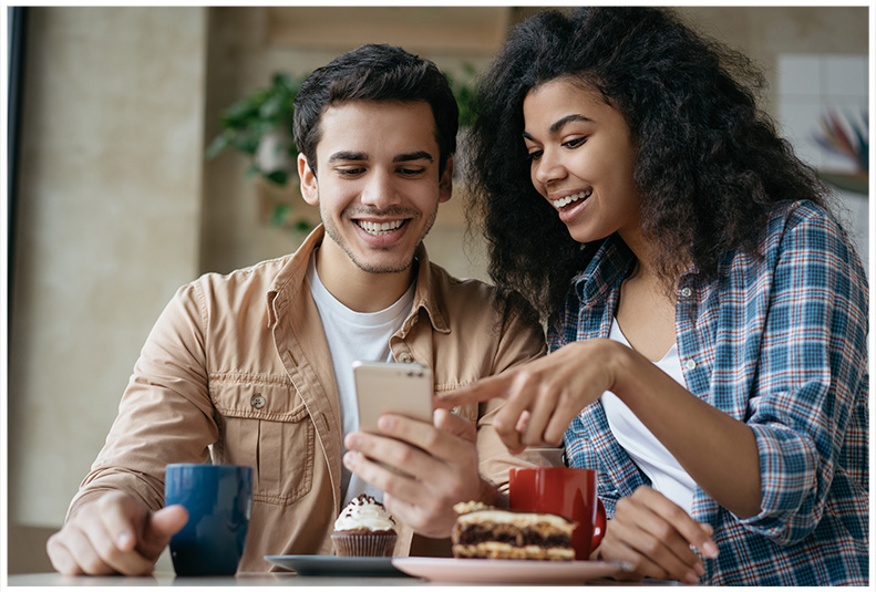 A smiling couple looking at a smartphone