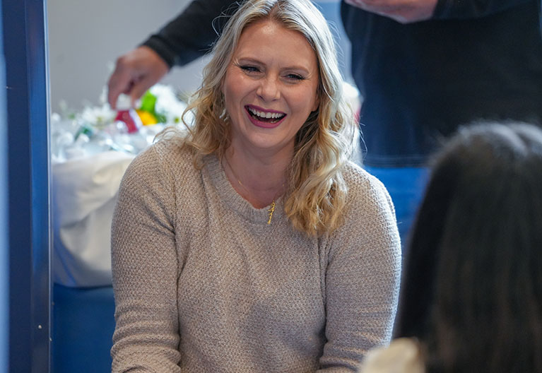 Employee smiling while attending a work event. 