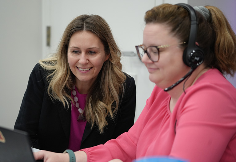 Two women in front of a computer in a call center