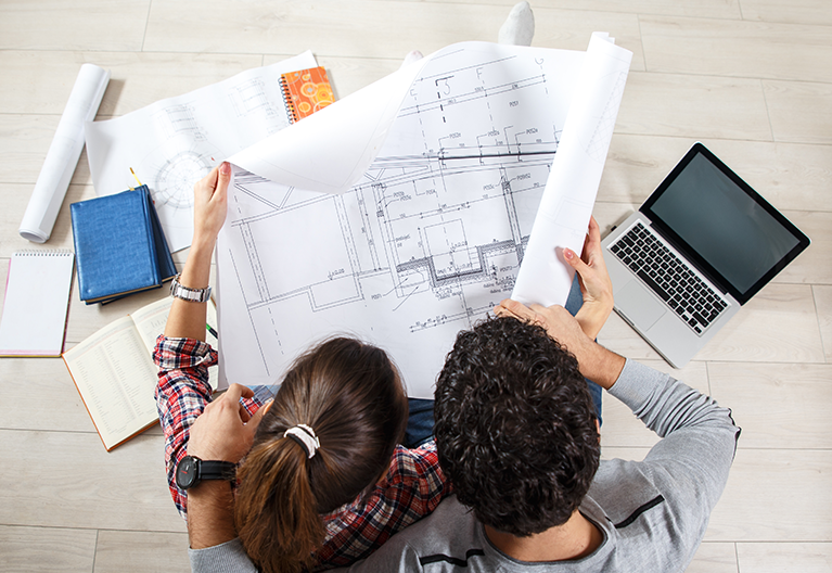 couple reviewing blueprint of home project plan