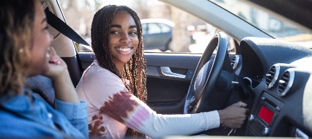 woman smiling in her car.