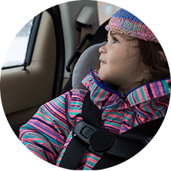 child in winter jacket sitting in car seat