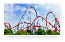 A rollercoaster with many loops and trees in the foreground.