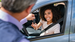 Teen driver being given key to a car.