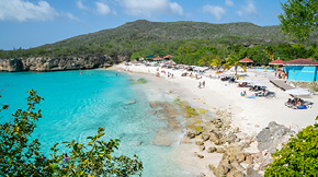 People sitting along Mambo Beach in Curacao on a sunny day. 