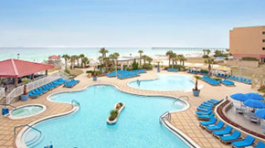 A pool and hot tub lined with chairs at a resort.