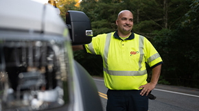 roadside technician standing with a car