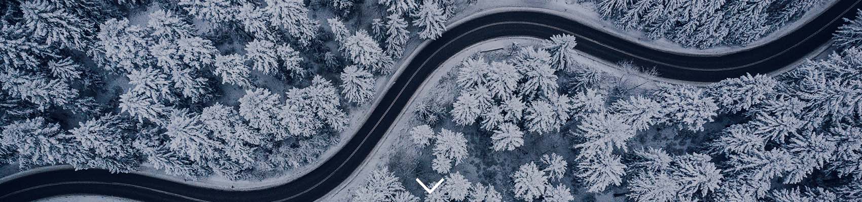 aerial view of a winter landscape with a windy road