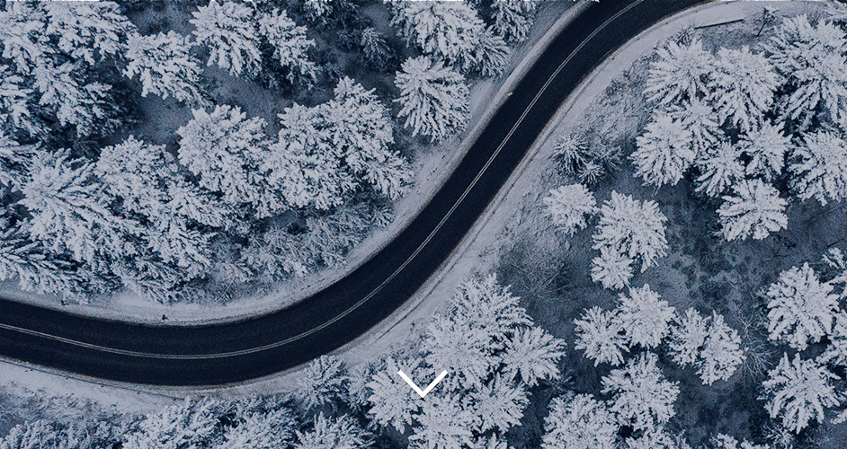 aerial view of a winter landscape with a windy road