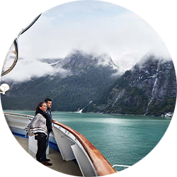 A couple observing the Alaskan coast from the starboard bow.