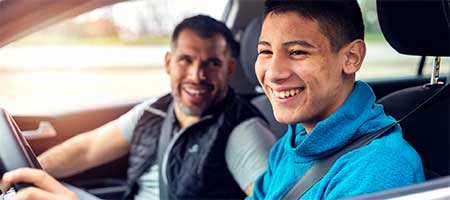 A father and son driving. 